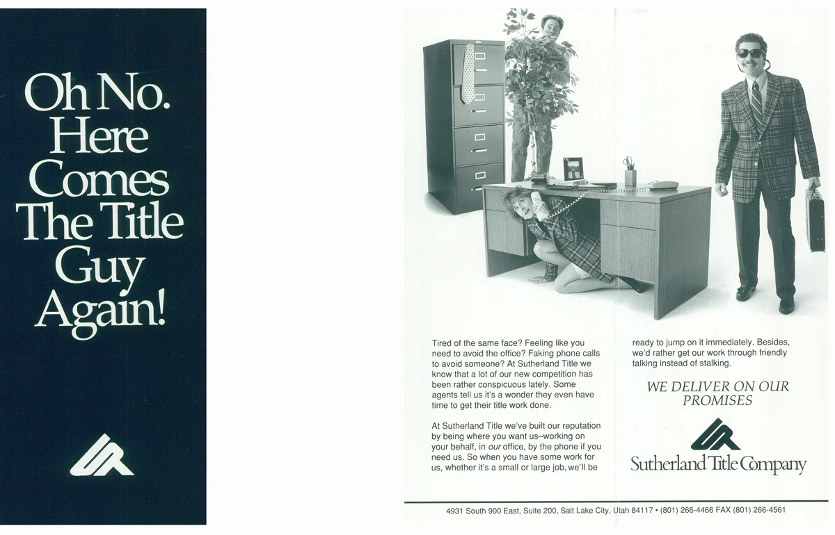 Black-and-white office scene with people hiding behind a plant and beneath a desk as a man carrying a briefcase arrives.